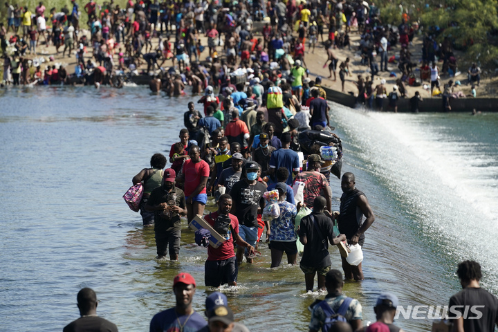 [텍사스(미국)=AP/뉴시스]9월17일 멕시코에서 미국으로 오기 위해 국경을 넘고 있는 아이티 이주민들. 2021.09.21.photo@newsis.com
