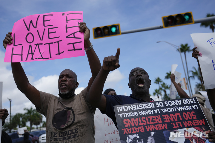 [마이애미=AP/뉴시스] 22일(현지시간) 미 플로리다주 마이애미의 미국 이민국 앞에서 아이티 공동체 회원들과 그 지지자들이 미국 국경에 도착한 아이티인들의 추방에 반대하는 시위를 벌이며 구호를 외치고 있다. 최근 수많은 아이티 난민이 국경지대로 몰려들어 텍사스주 국경지대에 대규모 불법 난민촌이 형성됐으며 미 국경 기마 순찰대원들의 아이티 난민을 비인격적으로 대하는 태도가 공개되며 논란이 되고 있다. 2021.09.23.