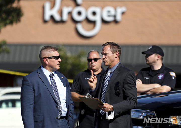 [콜리에빌( 미 테네시주)= AP/뉴시스]테네시주의 크로거 식품점 총격사건을 조사 중인 경찰관들이 현장에서 상황에 대해 의논하고 있다. 
