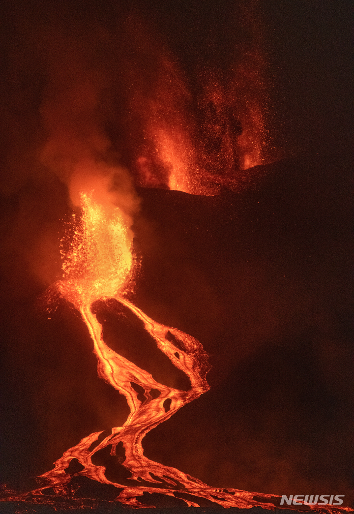 [라팔마=AP/뉴시스] 28일(현지시간) 스페인 카나리아 제도 라 팔마섬의 쿰브레 비에호 화산에서 용암이 흘러내리고 있다. 2021.09.29.