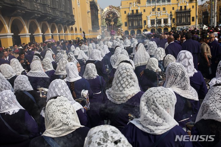 [리마(페루)=AP/뉴시스] 지난 2018년 3월 30일 열렸던 페루 최대의 종교행사 '기적의 주님' 행진을 앞두고 리마시내에서 여성 신도들이 미사보를 쓰고 향을 태우며 행진하는 광경. 이 행사는 코로나19의 대확산으로 지난해에 이어 올해에도 2년 연속 취소되었다고 리마의 대교구청이 9월28일 발표했다. 