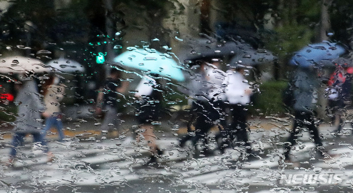 [서울=뉴시스] 홍효식 기자 = 비가 내린 지난달 29일 서울 시내 한 도로에서 시민들이 우산을 쓰고 발걸음을 옮기고 있다. 2021.09.29. yesphoto@newsis.com