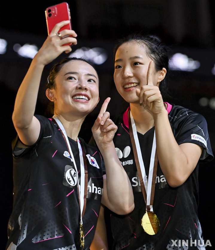 [도하=신화/뉴시스] 전지희(왼쪽)와 신유빈이 5일(현지시간) 카타르 도하의 루사일 스포츠아레나에서 열린 2021 ITTF-ATTU 아시아탁구 선수권 여자 복식 결승에서 홍콩의 리호칭-두호이켐을 물리치고 우승, 시상대에 올라 금메달을 목에 걸고 셀카를 찍고 있다. 전지희-신유빈은 결승전에서 홍콩을 세트스코어 3-1(11-5 7-11 11-3 11-4)로 꺾고 메이저대회 여자 복식 첫 우승을 일궈냈다. 2021.10.06.