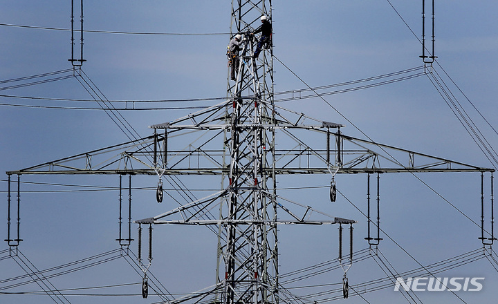 [뫼르스=AP/뉴시스]지난 2011년4월 독일 에너지 회사 RWE의 작업자들이 독일 서부 뫼르스의 한 철탑에서 작업하는 모습. 