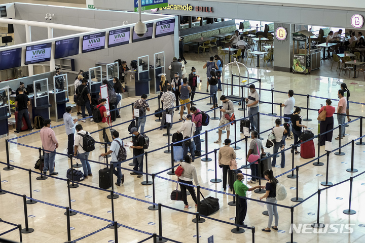 [칸쿤(멕시코)=AP/뉴시스]2020년 6월13일 관광객들은 멕시코 칸쿤의 공항에서 탑승 수속을 기다리고 있다. 지난 9월 멕시코 최대의 해안 휴양지 칸쿤의 공항 이용객 수가 코로나19 대유행 이전 수준을 넘어섰다. 2021.10.7