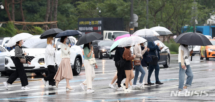 [서울=뉴시스] 이영환 기자 = 가을비가 내리고 있는 지난달 8일 오후 서울 종로구 광화문네거리에서 시민들이 우산을 쓰고 걸어가고 있다. 2021.10.08. 20hwan@newsis.com