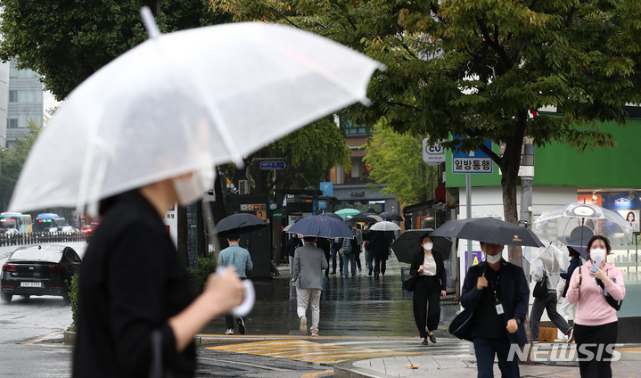 [서울=뉴시스] 이영환 기자 = 가을비가 내리고 있는 지난 8일 오후 서울 종로구 광화문네거리에서 시민들이 우산을 쓰고 걸어가고 있다. 2021.10.08. 20hwan@newsis.com