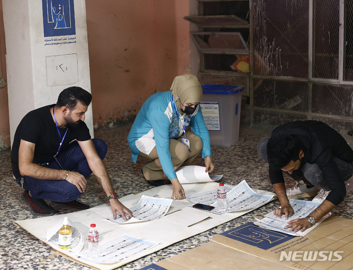 [바그다드(이라크)=AP/뉴시스]이라크 선거 관리인들이 10일(현지시간) 바그다드의 국회의원 선거 투표소를 닫고 개표 중이다. 2021.10.11.photo@newsis.com
