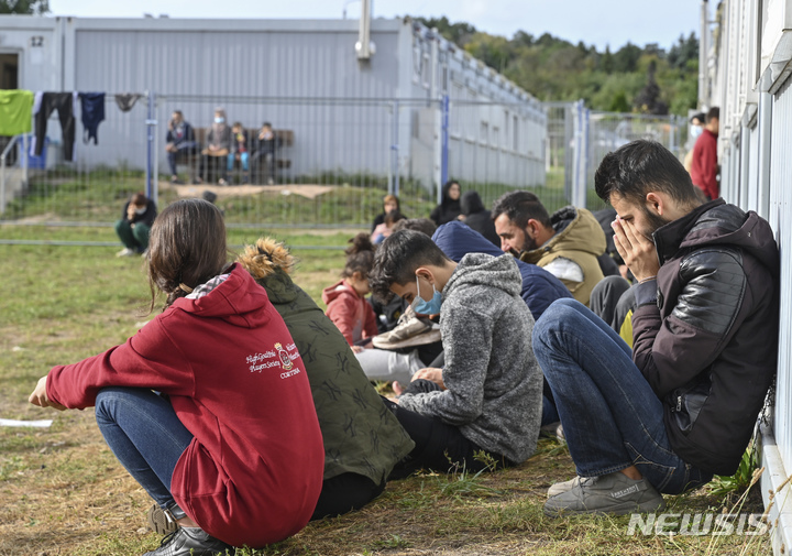 [브란덴브루크=AP/뉴시스]지난 6일(현지시간) 독일 아이젠휘텐슈타트주 브라덴부르크에 잇는 망명자 중앙초기접수시설 앞에 불법 이민자들이 앉아있다. 24일 독일 내무부에 따르면 올해에만 난민 6162명이 폴란드 국경을 통해 불법 입국했다. 대부분은 브란덴부르크 동부에 잇는 망명센터에 수용되고 있다. 2021.10.25.