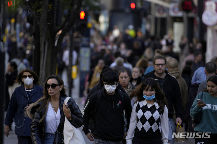 [런던(영국)=AP/뉴시스] 지난 20일(현지시간) 영국 런던에서 일부 시민들이 마스크를 쓰지 않은 채 거리를 걷고 있다. 2021.10.22.