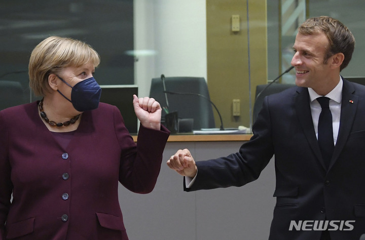 [브뤼셀(벨기에)=AP/뉴시스] 앙겔라 메르켈 독일 총리가(왼쪽) 지난 22일(현지시간) 벨기에 브뤼셀에서 열린 유럽연합 정상회의에서 에마뉘엘 마크롱 프랑스 대통령과 인사하고 있다. 2021.10.26.