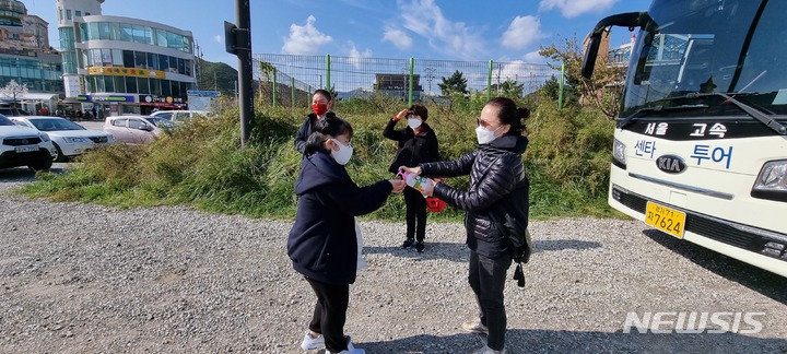 [서울=뉴시스] '2021 아름다운 우리 땅 독도탐방' 참가자들이 손 소독을 하는 모습. 