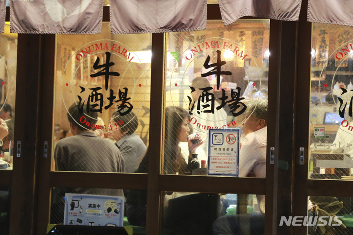 [도쿄(일본)=AP/뉴시스]일본 도쿄도의 음식점 영업시간 제한이 해제된 지난 25일 밤 한 술집 안에 시민들이 가득 차 있다. 2021.10.26.