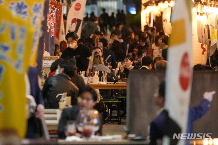[도쿄(일본)=AP/뉴시스]일본 도쿄도의 음식점 영업시간 제한이 해제된 지난 25일 밤 술집들의 테이블에 시민들이 모여있다. 2021.10.28.