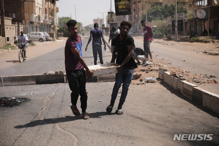 [하르툼=AP/뉴시스] 26일(현지시간) 수단 수도 하르툼에서 군부 쿠데타 반대 시위대가 도로에 바리케이드를 설치하고 있다. 