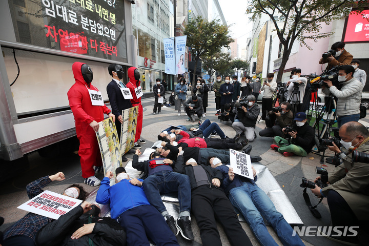 [서울=뉴시스] 조수정 기자 = 한국중소상인자영업자총연합회, 한국자영업자협의회 등 자영업자 단체 회원들이 27일 오전 서울 중구 명동예술극장 앞에서 자영업자 코로나19 손실보상 집행을 앞두고 임대료 분담 대책을 촉구하는 '코로나19 임대료를 멈춰라' 캠페인 돌입 기자회견을 열고 정부와 건물주 앞에 쓰러진 자영업자를 상징하는 퍼포먼스 하고 있다. 2021.10.27. chocrystal@newsis.com