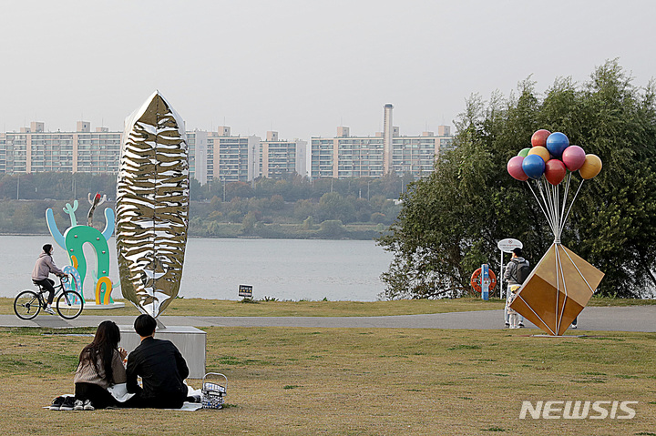 [서울=뉴시스]한강공원에서 크라운해태가 주최한_K-Sculpture 한강 흥 프로젝트_야외조각전시회 작품을 시민들이 관람하고 있다.