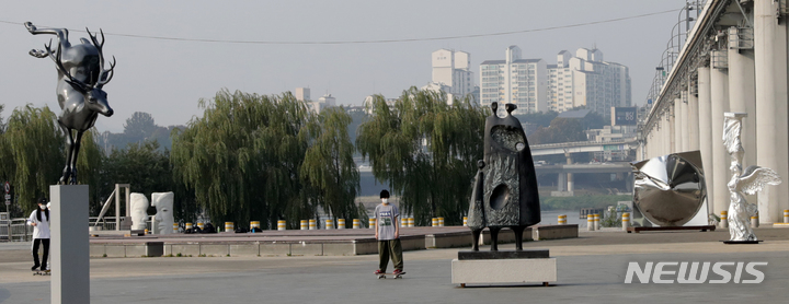 [서울=뉴시스]한강공원에서 크라운해태가 주최한_K-Sculpture 한강 흥 프로젝트_야외조각전시회 작품을 시민들이 관람하고 있다.