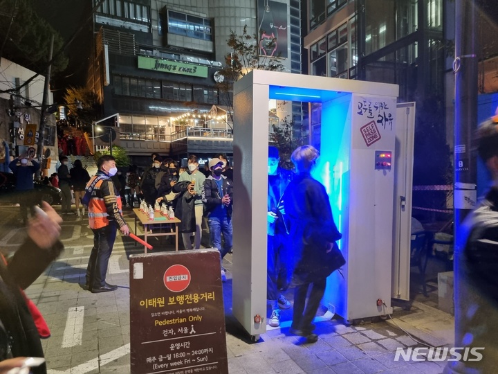 [서울=뉴시스]임하은 수습기자=30일 오후 시민들이 서울 이태원 세계음식거리에 설치된 방역게이트를 이용하고 있다. 2021. 10. 30. 