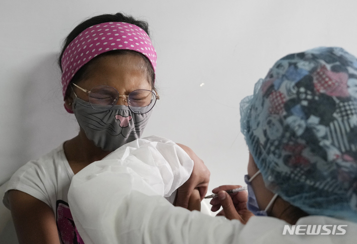 [보고타=AP/뉴시스] 8일(현지시간) 콜롬비아 보고타의 코스타 리카스 학교에서 한 어린이가 시노백 코로나19 백신을 접종하면서 인상을 찌푸리고 있다. 콜롬비아 정부는 3~11세 어린이들에게 코로나19 백신 접종을 시작했다. 2021.11.09.