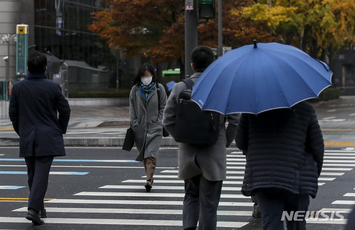 [서울=뉴시스] 정병혁 기자 = 서울 지역에 첫 눈이 내린 지난 10일 오전 서울 종로구 광화문네거리에서 우산을 쓴 시민들이 발걸음을 옮기고 있다. 2021.11.10. jhope@newsis.com