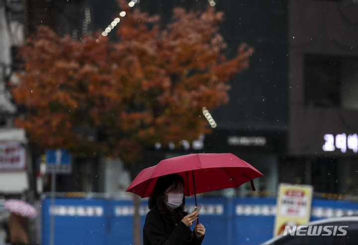 [서울=뉴시스] 정병혁 기자 = 서울 지역에 첫 눈이 내린 지난 10일 오전 서울 종로구 광화문네거리에서 우산을 쓴 시민들이 발걸음을 옮기고 있다. 2021.11.10. jhope@newsis.com