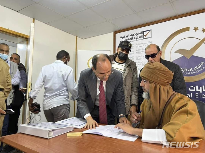 [사브하=AP/뉴시스] 리비아 독재자 무아마르 카다피의 아들인 사이프 알이슬람 카다피(오른쪽)가 14일(현지시간) 리비아 사브하에서 대선 후보 등록을 하고 있다. 리비아 대선은 오는 12월24일 실시될 예정이다. 2021.11.16.
