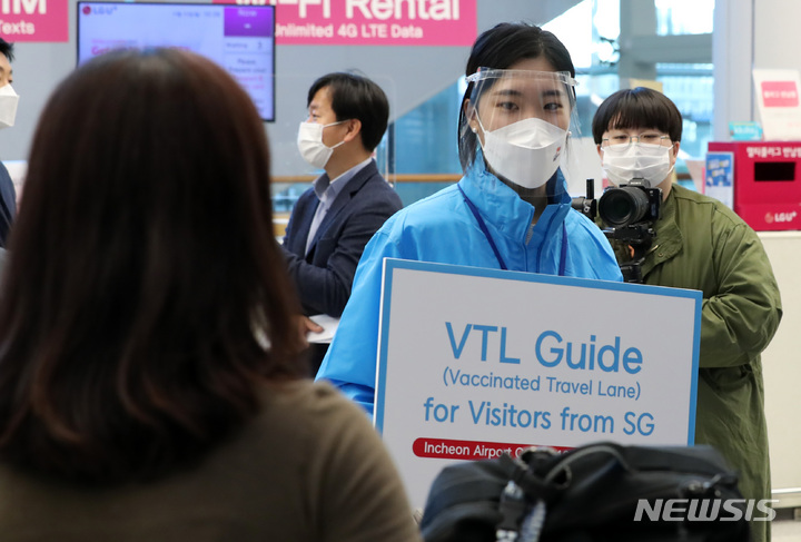 [인천공항=뉴시스] 이영환 기자 = 15일 오전 인천국제공항 제2여객터미널을 통해 싱가포르 관광업계 및 미디어 팸투어단이 입국하자 한 직원이 안내를 하고 있다. 이들은 이날부터 한국-싱가포르간 여행안전권역(Vaccinated Travel Lane) 시행에 따라 입국한 관광객들로 코로나19 이후 국내를 찾은 첫 외국인 관광객이다. 2021.11.15. 20hwan@newsis.com