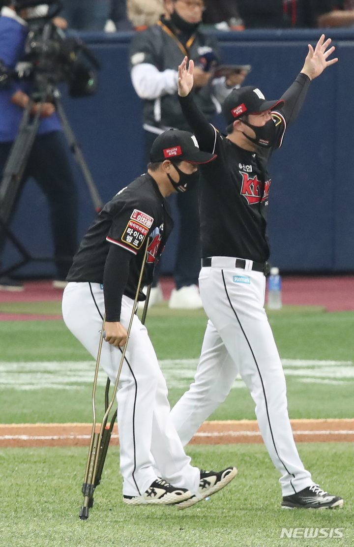 [서울=뉴시스] 조수정 기자 = 18일 오후 서울 구로구 고척스카이돔에서 열린 2021 KBO 한국시리즈 두산 베어스와 KT 위즈의 4차전 경기, 8-4로 최종 승리를 거둔 KT 선수들을 향해 목발 짚은 박경수가 기쁨을 나누기 위해 이동하고 있다. 2021.11.18. chocrystal@newsis.com