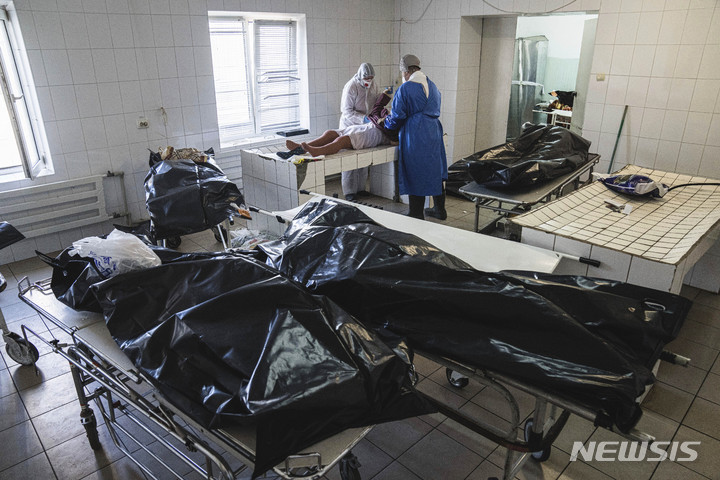 [AP/뉴시스] 10월29일 우크라이나의 카호프카 병원 영안실에서 의료 종사자들이 코로나19로 사망한 시신을 수습하고 있다. 우크라이나는 최근 하루 656명 씩 사망해 미국, 러시아 다음으로 일일 사망자가 많다