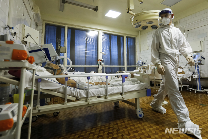 [볼고그라드=AP/뉴시스] 지난달 21일(현지시간) 러시아 볼고그라드의 한 병원 중환자실에서 방호복을 입은 의료인이 코로나19 환자들을 돌보고 있다.2021.12.24.