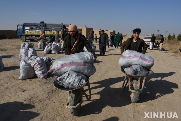 [ 마자르이 샤리프( 아프가니스탄)=신화/뉴시스] 아프가니스탄의 발크주 주민들이 지난 해 11월 22일 지역 구호단체로부터 식량등 구호품을 배급받고 집으로 돌아가고 있다.  혹한을 앞둔 아프간에서는 전국 대부분에서 생계가 막연한 주민들에게 유엔과 구호단체들이 현금, 식량, 생필품등의 긴급 배급에 나섰다.