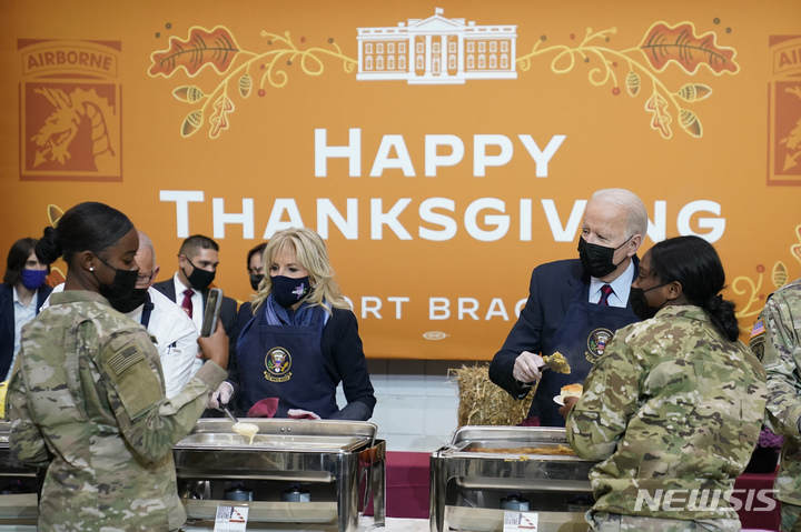 [포트브래그=AP/뉴시스] 조 바이든 미국 대통령과 질 바이든 여사가 다가오는 추수감사절(25일)을 맞아 22일(현지시간) 미 노스캐롤라이나주 포트 브래그를 방문해 장병들에게 저녁 식사를 배식하고 있다. 2021.11.23.