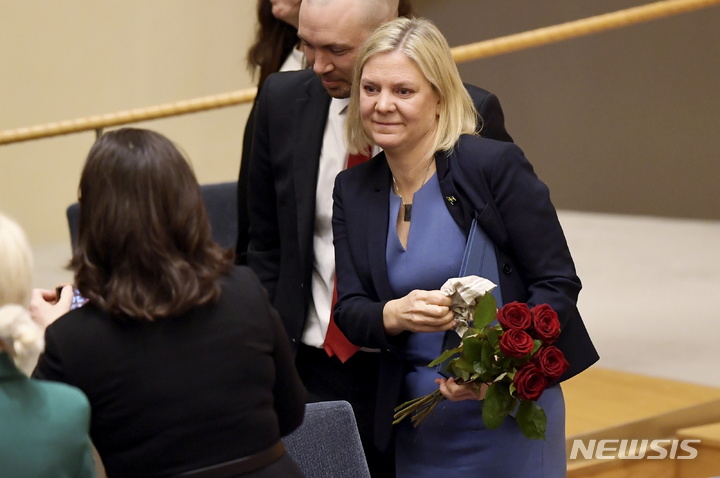 [스톡홀름(스웨덴)=AP/뉴시스] 막달레나 안데르손 스웨덴 총리가 24일(현지시간) 스웨덴 스톡홀름 의회에서 열린 의회 인준 투표에서 신임 총리로 선출된 뒤 꽃다발을 받고 있다. 2021.11.25.