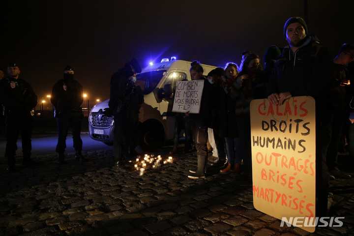 [칼레=AP/뉴시스] 24일(현지시간) 프랑스 북부 칼레항 주변에서 난민 권리 옹호 단체와 활동가들이 "인권, 분노" 등이 쓰인 팻말을 들고 있다. 2021.11.25.