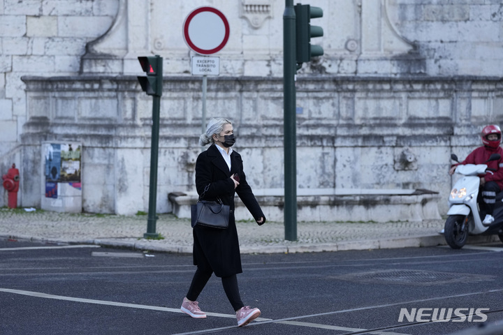 [리스본=AP/뉴시스] 지난 25일(현지시간) 포르투갈 리스본에서 마스크를 쓴 한 여성이 길을 걷고 있다. 이날 포르투갈은 코로나19 규제 조치를 대부분 해제한 지 7주 만에 다시 국가비상사태를 선포하고 고강도 규제 조치를 발표했다. 2021.11.30.