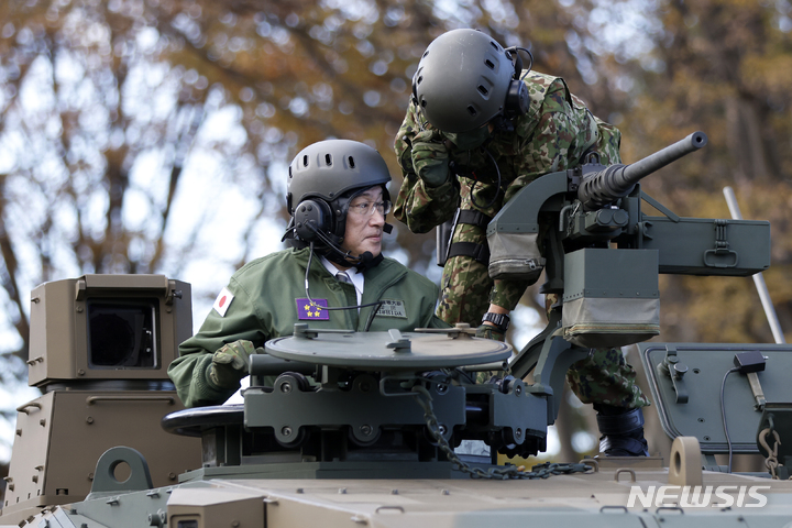 [도쿄=AP/뉴시스]일본 자위대가 출범한 지 1일 70주년을 맞았다. 기시다 후미오 일본 총리(사진 왼쪽)가 2021년 11월27일 도쿄에 위치한 육상자위대 아사카 캠프에서 전차를 타고 있다. 2024.07.01.