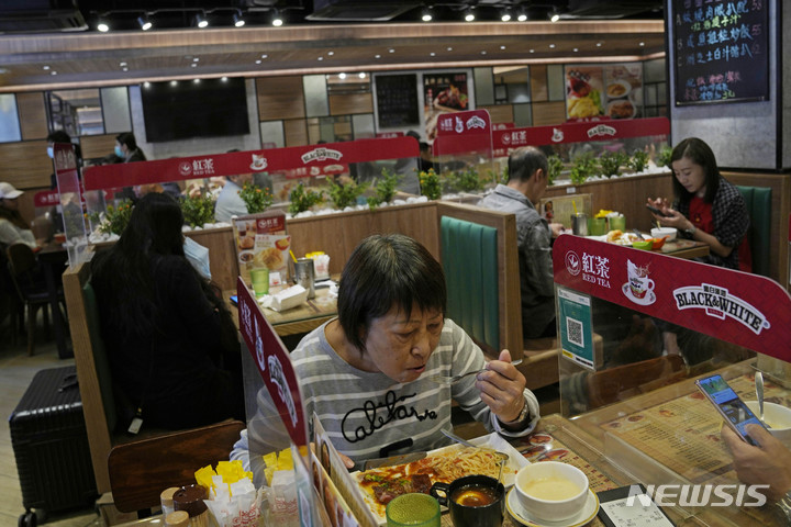 [홍콩=AP/뉴시스] 29일 홍콩의 한 음식점에서 고객들이 가림막이 설치된 테이블에 앉아 식사를 하고 있다. 2021.11.30