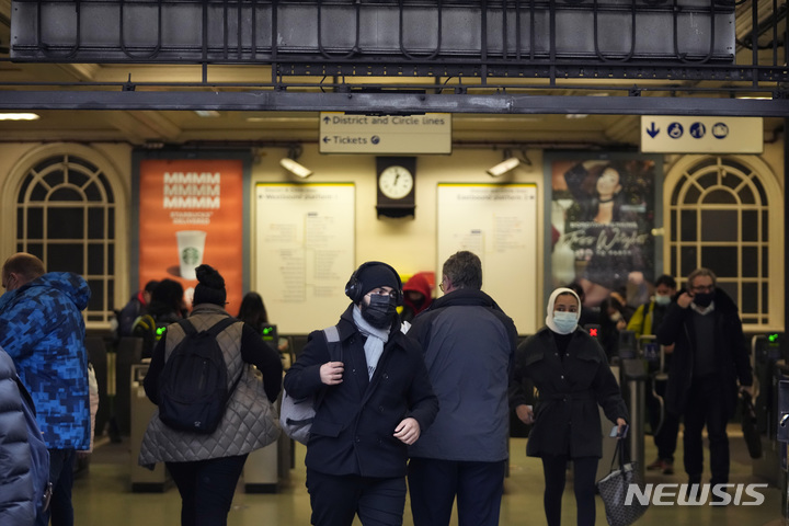[런던(영국)=AP/뉴시스] 오미크론 변이 바이러스로 마스크 착용이 다시 의무화된 지난달 30일(현지시간) 영국 런던 템플 지하철역에서 사람들이 마스크를 쓴 채 걷고 있다. 2021.12.02.