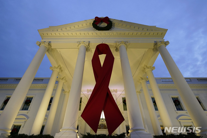 [워싱턴=AP/뉴시스] 세계 에이즈의 날인 지난 2021년 12월1일(현지시간) 백악관 정면에 붉은 리본이 장식돼 있다. 붉은 리본은 HIV 감염자와 에이즈 환자의 인권을 보호하고 그들에 대한 지지를 나타낸다. 2021.12.02.