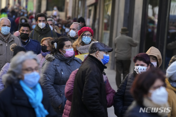 [마드리드=AP/뉴시스]지난 2일(현지시간) 스페인 마드리드에서 코로나19 감염 예방을 위해 마스크를 쓴 시민들이 크리스마스 복권을 사기 위해 줄을 서고 있다. 2021.12.07.