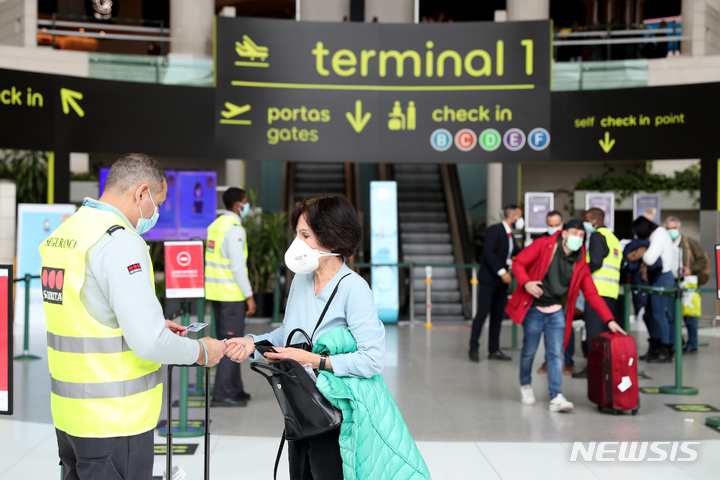 [ 리스본( 포르투갈)= 신화/뉴시스] 포르투갈의 리스본 공항에서 지난 해 말 여객들의 코로나19 백신접종 증명서를 검사하는 모습.  이 공항은 올 해  7월2일 활주로의 사고로 무려 65편의 항공편이 취소되면서 수 천명의 이용객들이 큰 불편을 겪었다.    *재판매 및 DB 금지