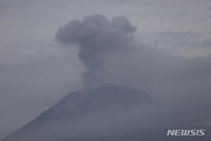 [자바(인도네시아)=AP/뉴시스]5일 인도네시아 자바섬 동부에 위치한 스메루 산이 분화하며 화산재를 분출하고 있다. 2021.12.05.