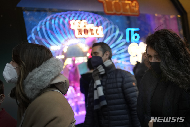 [파리=AP/뉴시스] 6일(현지시간) 프랑스 파리에서 마스크를 쓴 시민들이 성탄 조명이 밝혀진 상점 앞을 지나고 있다. 2021.12.07.