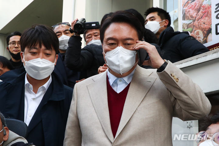 [서울=뉴시스] 국회사진기자단 = 윤석열 국민의힘 대선 후보와 이준석 대표가 8일 서울 종로구 대학로 거리 플랫폼74에서 열린 청년문화예술인 간담회 참석 전 통화하고 있다. 2021.12.08. photo@newsis.com