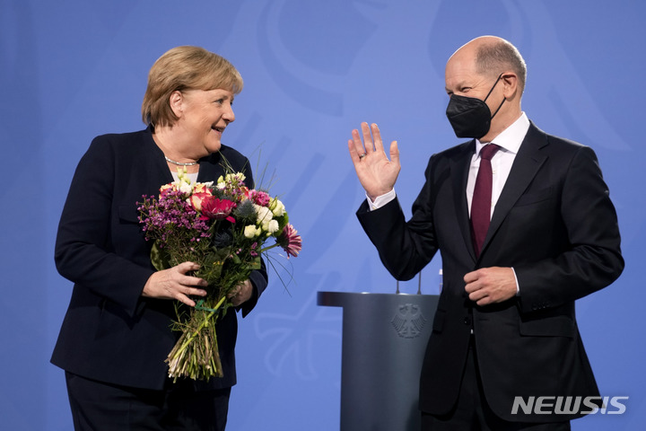 [베를린=AP/뉴시스] 앙겔라 메르켈 전 독일 총리가 8일(현지시간) 베를린 총리실에서 올라프 숄츠 신임 독일 총리로부터 꽃다발을 받고 웃고 있다. 총선 불출마 선언으로 스스로 총리직에서 내려온 메르켈 총리는 첫 여성·동독 출신 총리로 2005년부터 16년간 재직하면서 독일뿐 아니라 유럽연합(EU), 나아가 세계를 이끄는 지도력을 보여주고 물러났다. 2021.12.09.