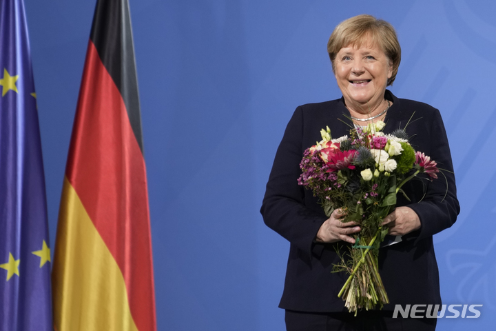 [베를린=AP/뉴시스]앙겔라 메르켈 전 독일 총리가 퇴임 3년 만인 오는 11월 회고록을 출간한다. 사진은 메르켈 전 총리가 2021년 12월8일(현지시각) 독일 베를린 총리실에서 후임자인 올라프 숄츠 독일 총리로부터 꽃다발을 받고 웃는 모습. 2024.05.14.