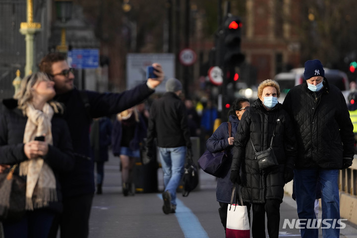 [런던(영국)=AP/뉴시스] 9일(현지시간) 영국 런던에서 일부 시민들이 마스크를 쓴 채 걷고 있다. 2021.12.10.