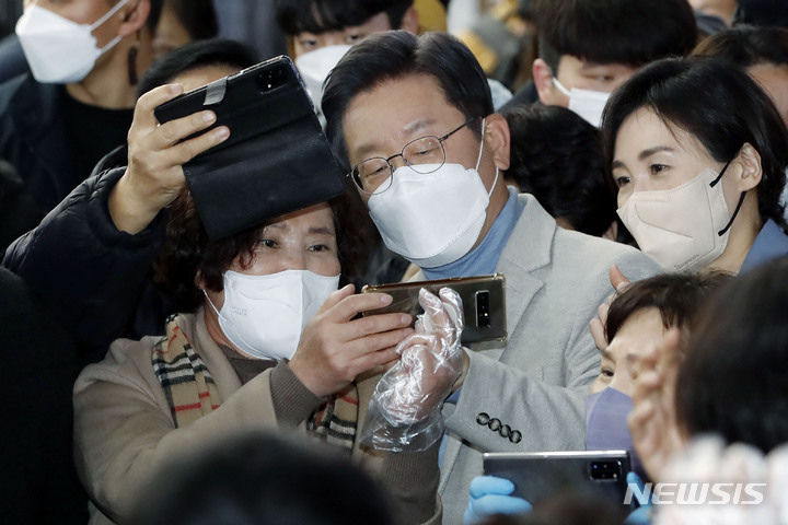 [대구=뉴시스] 최동준 기자 = 이재명 더불어민주당 대선 후보, 부인 김혜경 씨가 10일 대구 동성로를 방문해 시민들과 기념촬영을 하고 있다. 2021.12.10. photocdj@newsis.com