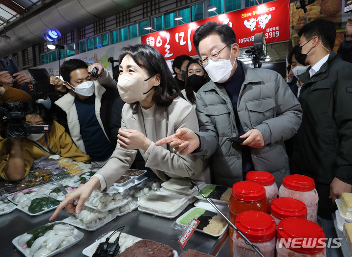 [안동=뉴시스] 최동준 기자 = 이재명 더불어민주당 대선 후보, 부인 김혜경 씨가 11일 경북 안동 중앙신시장을 방문해 안동식혜를 구매하고 있다. (공동취재사진) 2021.12.11. photo@newsis.com